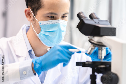 professional research scientist concentration using microscope in chemistry medicine laboratory, technician working with medical science technology equipment for biotechnology or biology experiment
