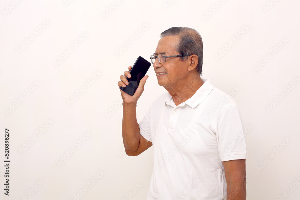 Happy Elderly asian man standing while talking on the phone. Isolated on white background Happy Elderly asian man standing while talking on the phone. Isolated on white background