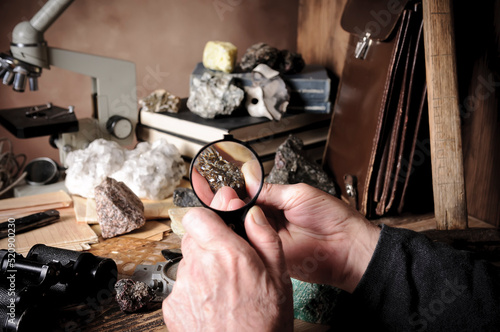 Geologist examining a mineral sample under a magnifying glass