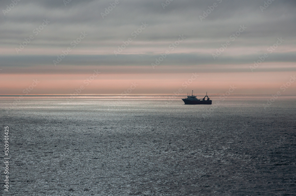 A deep-sea fishing vessel anchored close to shore in the Atlantic Ocean A deep-sea fishing vessel anchored close to shore in the Atlantic Ocean