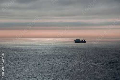A deep-sea fishing vessel anchored close to shore in the Atlantic Ocean