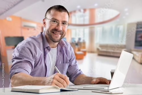 Satisfied man looking at computer screen  reading good news in email  chatting in social network with friends  freelancer blogger working on online project