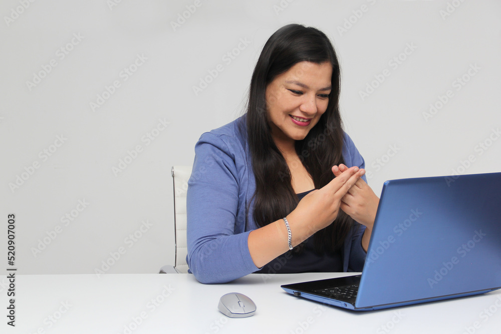 Latino adult woman speaks Mexican sign language with a deaf person through a laptop in a video call
Latino adult woman speaks Mexican sign language with a deaf person through a laptop in a video call
