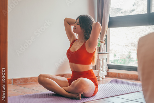 Portrait of blonde beautiful woman doing yoga and relaxing her mind and her body at home on the floor. One active and heathy girl taking care of health training.