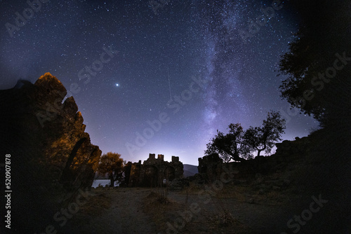 night view of the castle. A view of the stars of the Milky Way with a mountain top in the foreground. Night sky nature summer landscape. Perseid Meteor Shower observation