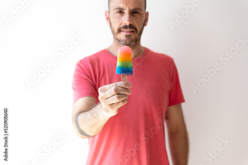 gay man holding an ice cream with the color of the rainbow, symbol of the LGTBI collective
