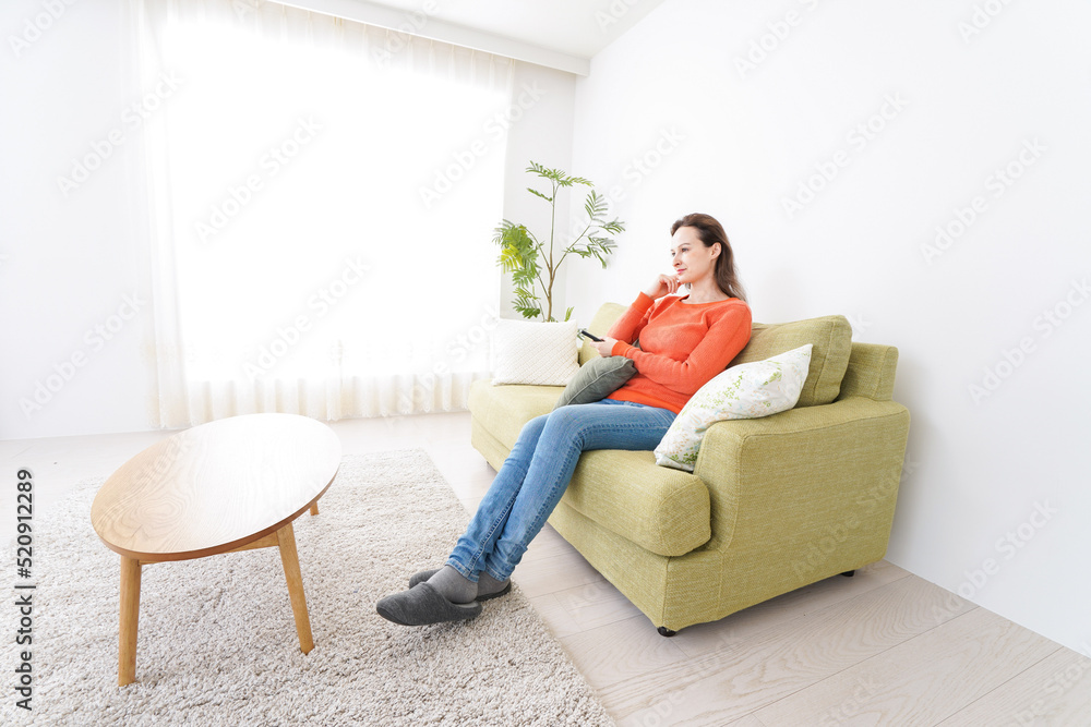 家でテレビを見る女性 家でテレビを見る女性