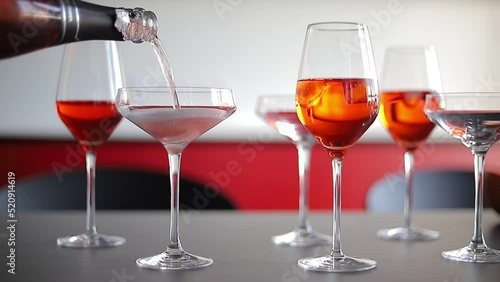 Red drink champagne is pouring into a glass