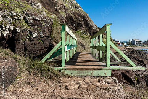 small green wooden bridge on the stones