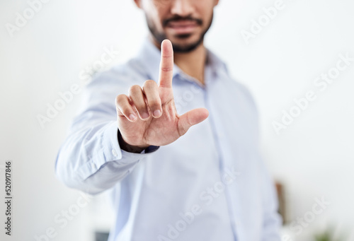 Modern, future and futuristic business man pointing his finger up pressing an empty virtual touchscreen. Closeup portrait of a corporate professional male touching an invisible screen or in an office