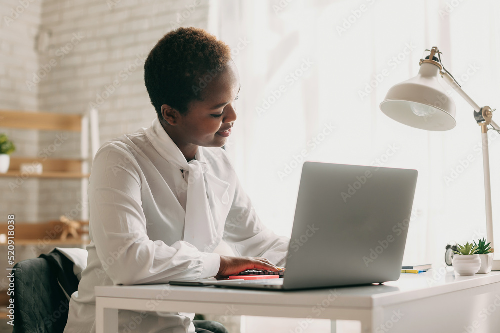 Black student, writing notes, watching webinar on laptop, studying online. Attending virtual business meeting. Seminar. Black student, writing notes, watching webinar on laptop, studying online. Attending virtual business meeting. Seminar.