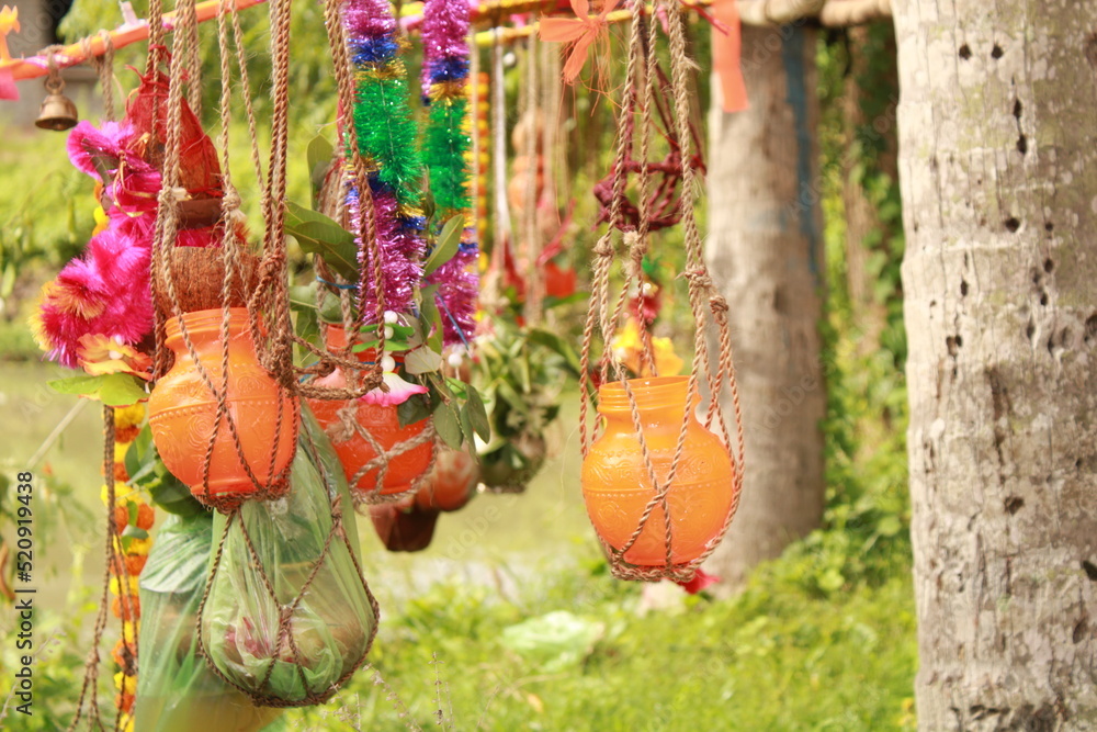 Fototapeta premium Closeup of Kanwarias kept their Holy Gangajal pots. Small bamboo pole on which two earthen, plastic and brass pots are hung on either end for carrying the Gangajal coconut, flower, mango leafs.