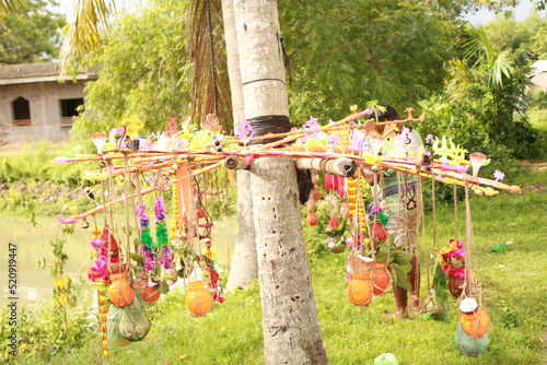 Closeup of Kanwarias kept their Holy Gangajal pots. Small bamboo pole on which two earthen, plastic and brass pots are hung on either end for carrying the Gangajal coconut, flower, mango leafs. photo