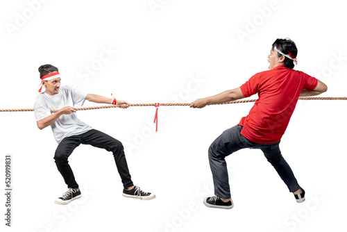 Two Indonesian men celebrate Indonesian independence day on 17 August with the tug of war contest