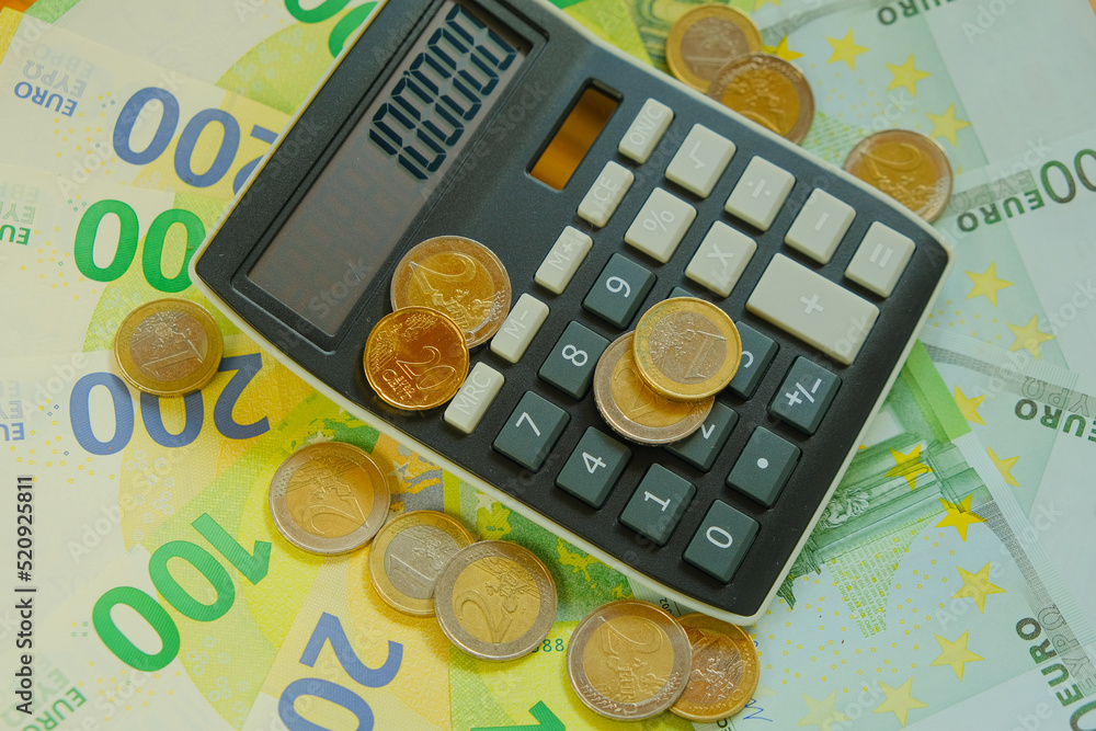Calculator and euro coins on banknotes background.Taxes in EU  countries.Euro currency.Budget allocation.Recalculation of money. Expenses  and incomes in European countries. foto de Stock | Adobe Stock