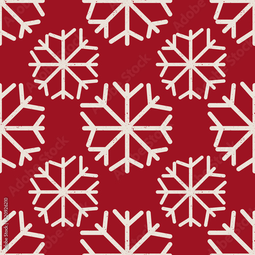 Seamless Christmas snowflake pattern. Seamless vector white snowflakes of different sizes on red background for fabric or wrapping paper print. 