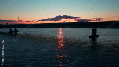 Aerial view of traffic on the Lapinlahti bridge with a colorful sunset background - ascending, drone shot photo