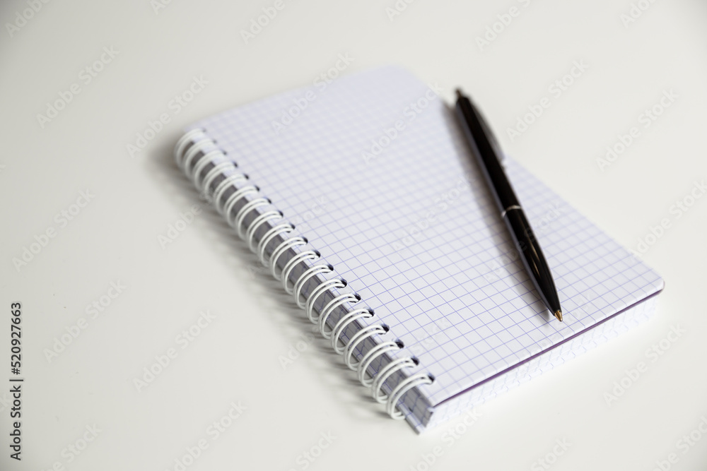 Notepad and pen close-up on the table surface. Notepad and pen close-up on the table surface.