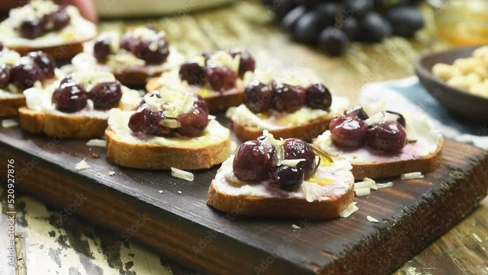 The chef serves the freshly prepared roasted grapes crostini.
The chef serves the freshly prepared roasted grapes crostini.
