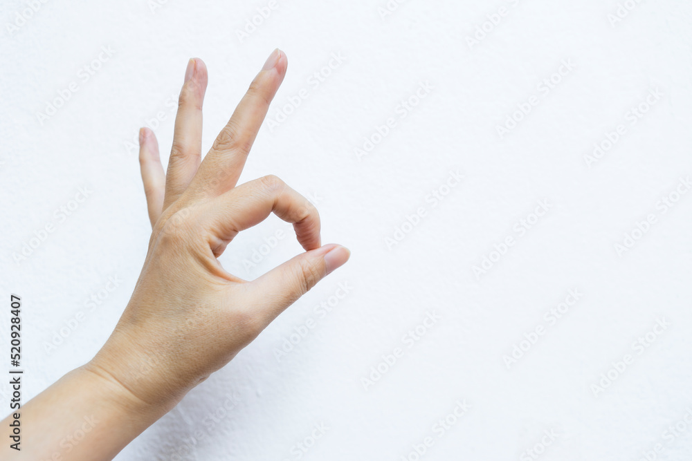 Female hand with ok hand gesture on white cement wall background, sign gesture Female hand with ok hand gesture on white cement wall background, sign gesture