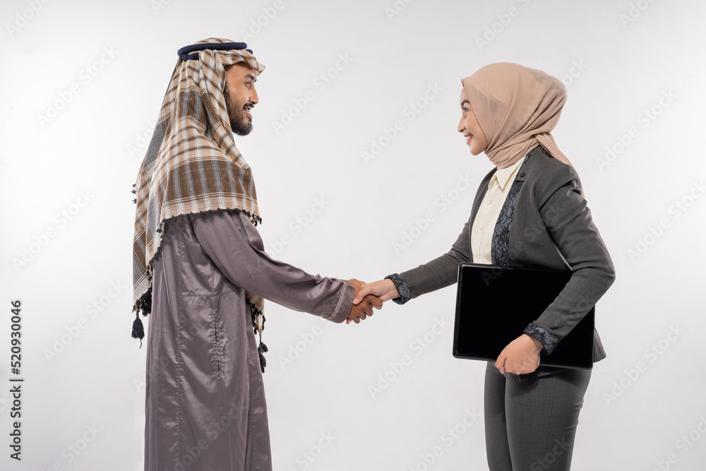 Fototapeta premium asian muslim man and woman shaking hand. partnership greeting over white background