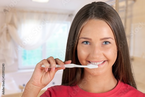 Happy female portrait. Teenager girl brushing her teeth. Daily hygiene  morning routine. Dental health oral care. Smiling girl.