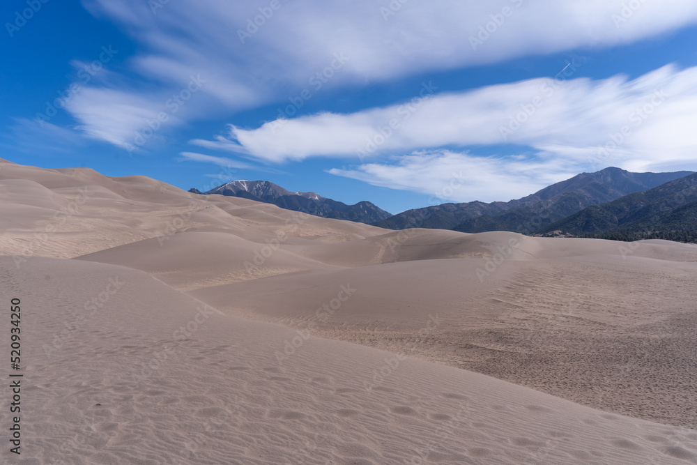 Sand Dunes with Mountains and Clouds