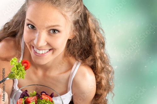 Sport, wellbeing and active lifestyle concept. Happy female athlete fitness girl holding salad
