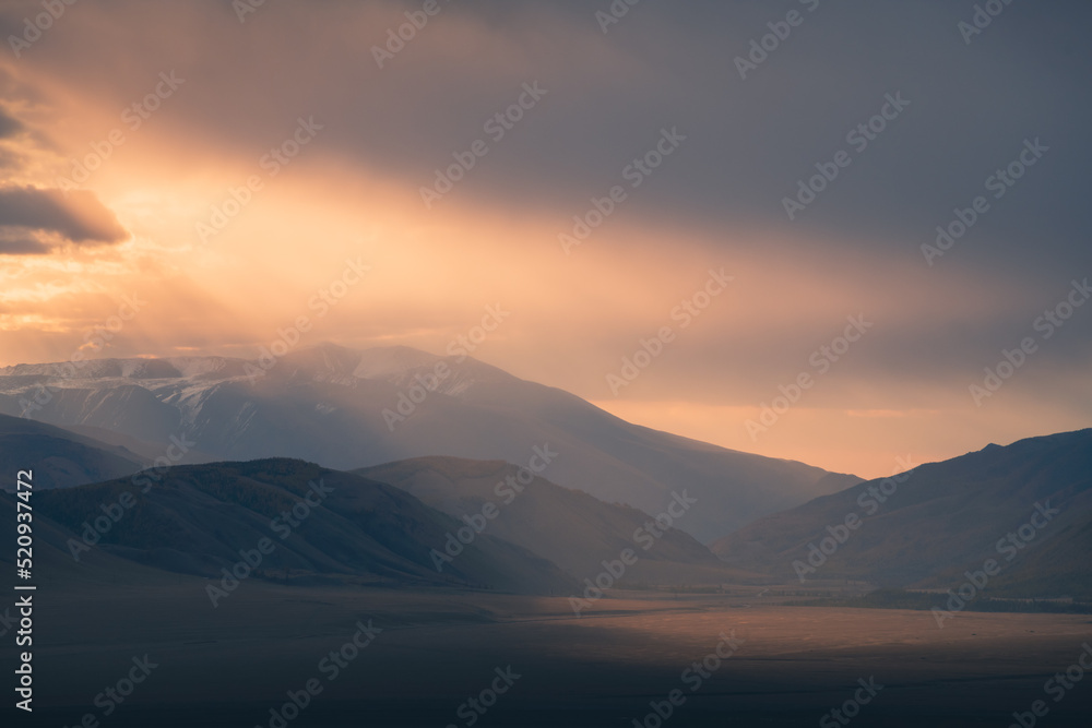 Mountains with clouds in the morning sunlight. Altai, Russia.