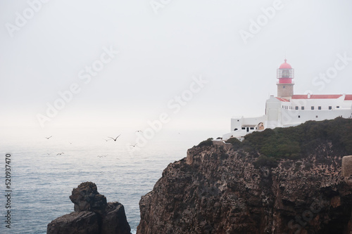 Lighthouse on Cape St. Vincent at foggy evening in Algarve, Portugal.