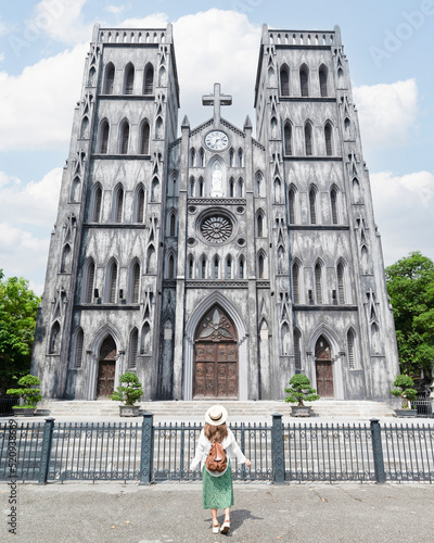 Woman traveller is sightseeing at St Joseph's Cathedral (Nha Tho Lon in Vietnamese) in Hanoi, Vietnam photo