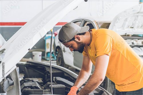 Pakistani or Indian Mechanic repairing a car in garage