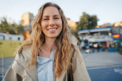 Portrait of a charming young woman posing for camera in the city