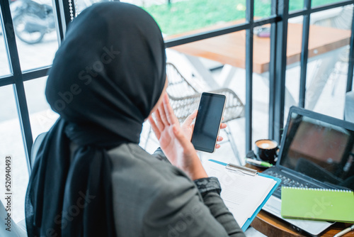 portrait of happy excited muslim woman suprised while looking at her phone