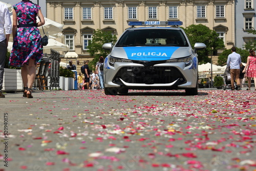 Police car in the street covered with petals drationally trown during Corpus Christi procession in Poland