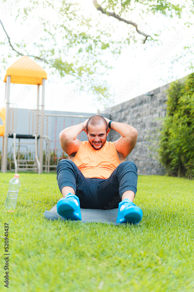 Fototapeta premium Young latin guy exercising on the ground in the park