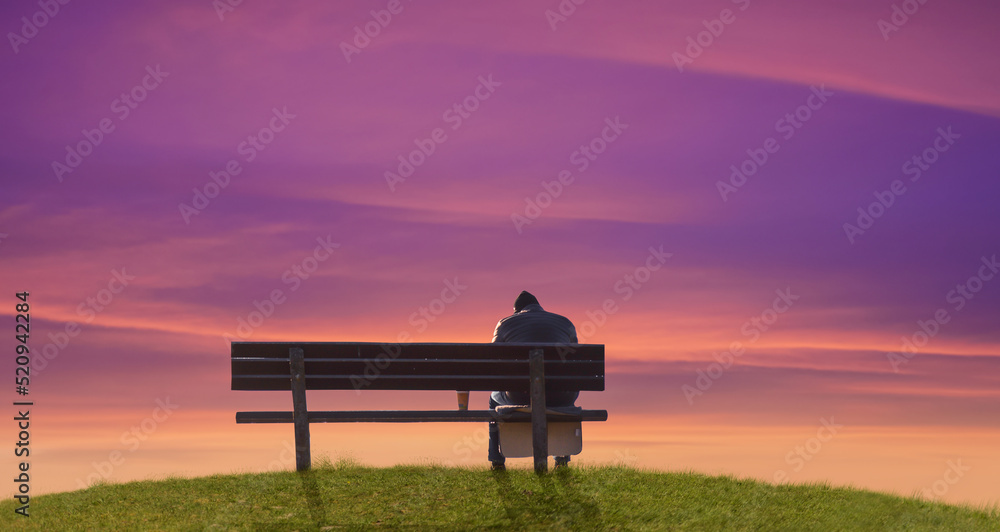 a sad silhouette man on a bench at evening sunset. a sad silhouette man on a bench at evening sunset.