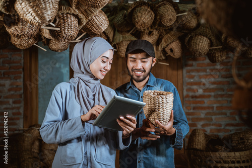 entrepreneur man and woman using tablet to sell water hyacinth crafts online on production house background