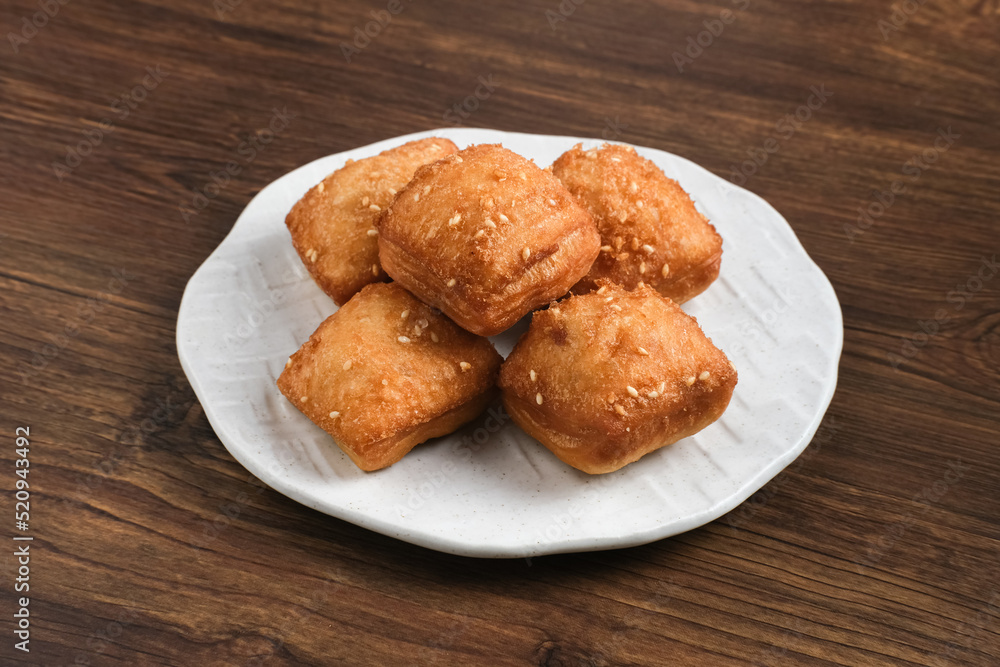Bolang baling, Odading, fried bread in cubes or blocks, with a light brown crunchy outer skin and sprinkled with sesame seeds, the inside is empty and fluffy, so it looks like a small pillow.
