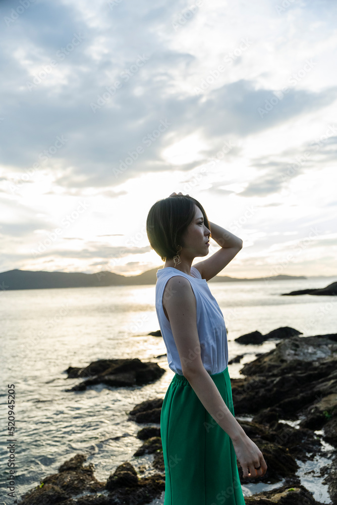 夕暮れの海にいる女性