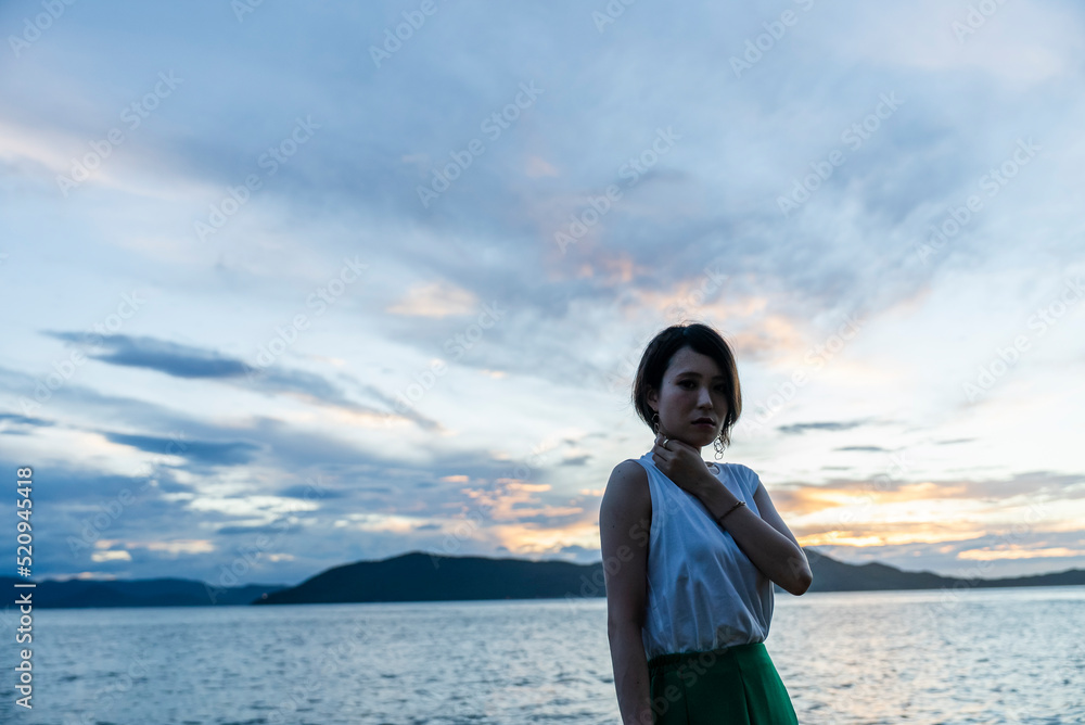 夕暮れの海にいる女性