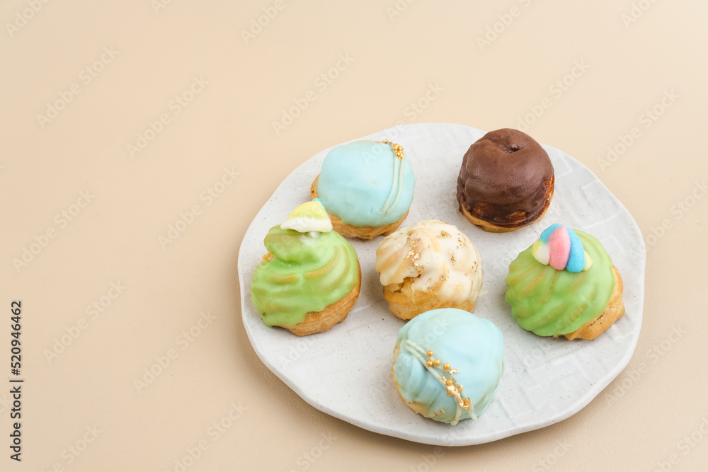 Choux pastry contains butter, water, flour, and eggs. Colorful choux with chocolate glaze. Choux pastry contains butter, water, flour, and eggs. Colorful choux with chocolate glaze.