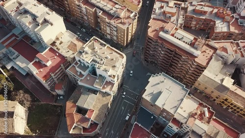 Aerial top down shot of cars on road between apartment blocks in city of Murcia,Spain during sunlight photo
