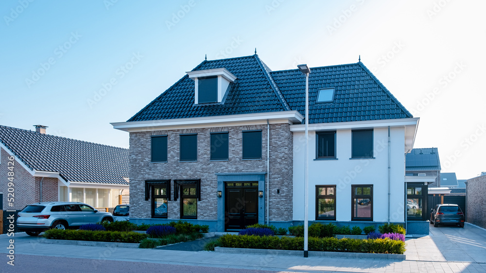 Dutch Suburban area with modern family houses, newly build modern family homes in the Netherlands, dutch family houses in the Netherlands, newly build streets with modern houses.  - obrazy, fototapety, plakaty 