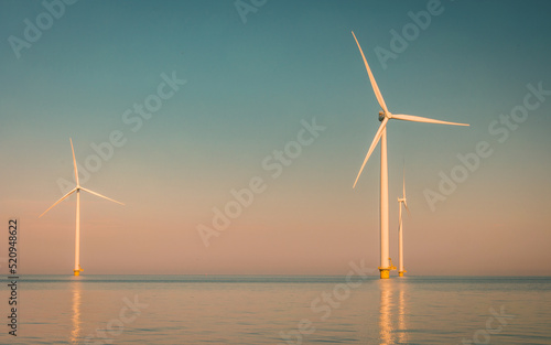offshore windmill park with stormy clouds and a blue sky, windmill park in the ocean. Netherlands . Europe, windmill turbines in ocean with blue sky, green energy concept