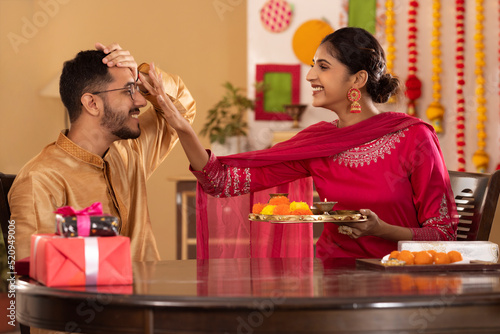 Sister applying tika on her brother's forehead on the occasion of Raksha Bandhan