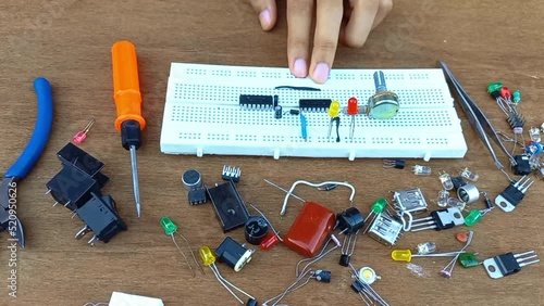 man hand making electrical circuit on bread board 