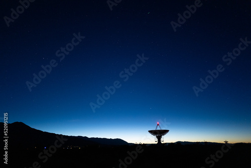landscape wide shot of Owen Valley Radio Observatory under dark sky at dusk and crescent moon