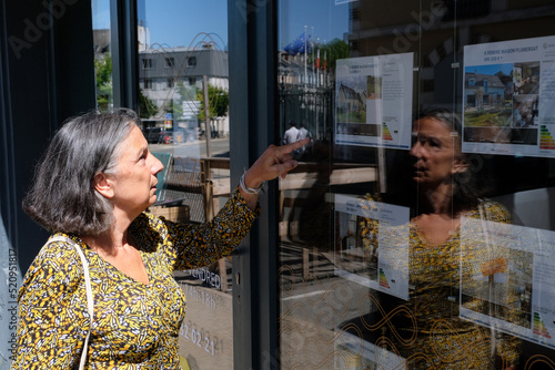 Vannes, France, 30 juillet 2022 : Femme regardant les annonces d'une agence immobiliere de la ville de Vannes photo