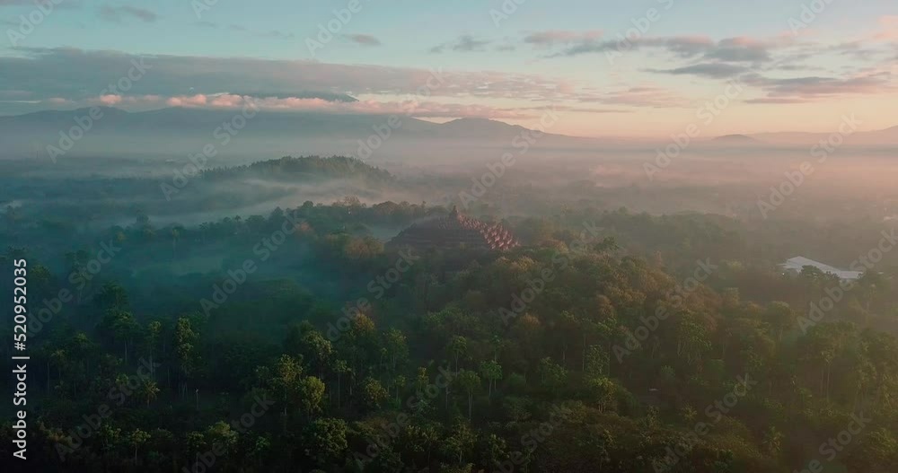beautiful drone flight with view over the borobudur temple indonesia and the surrounding mountains in an orange sunrise beautiful drone flight with view over the borobudur temple indonesia and the surrounding mountains in an orange sunrise